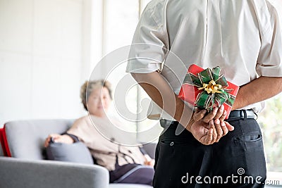 senior asia man hiding present for his wife behind back on valentineday . Senior couple asia celebrating anniversaryday. senior Stock Photo