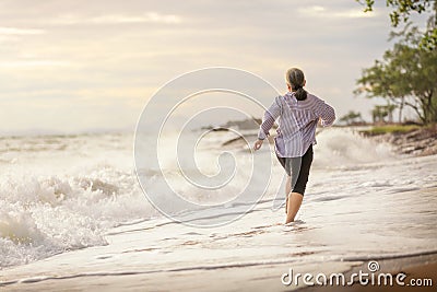 Senior Asia woman dancing on the beach Stock Photo