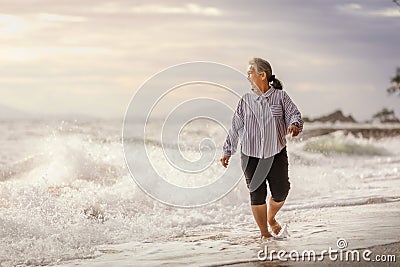 Senior Asia woman dancing on the beach Stock Photo