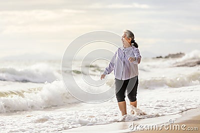 Senior Asia woman dancing on the beach Stock Photo