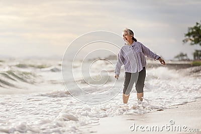 Senior Asia woman dancing on the beach Stock Photo