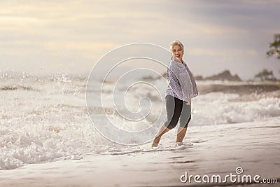 Senior Asia woman dancing on the beach Stock Photo