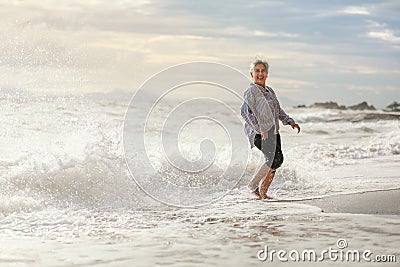 Senior Asia woman dancing on the beach Stock Photo