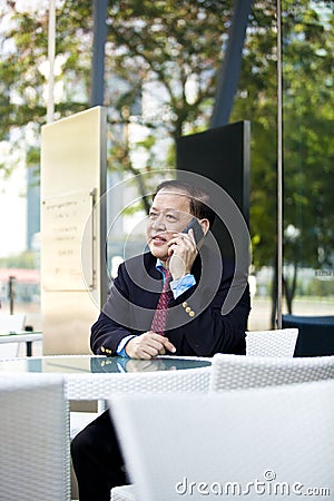 Senior Asian businessman using smart phone Stock Photo