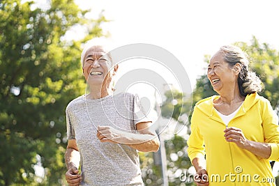 Senior asian couple running in park Stock Photo