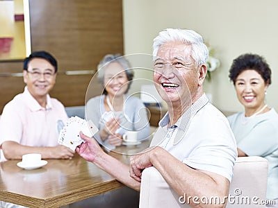 Senior asian man in playing cards with friends Stock Photo