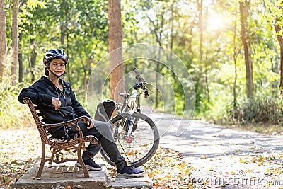 Senior asian woman bicycle with sitting in the park Stock Photo