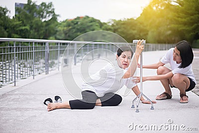 Senior asian woman with faint sitting on floor after falling down,female take care and support Stock Photo