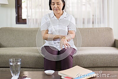 Senior asian woman suffering with parkinson`s disease symptoms on hands Stock Photo