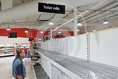 Senior Australian man looking at empty toilet rolls self in supermarket worried about the Coronavirus outbreak Editorial Stock Photo