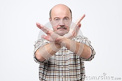 Senior bald man with mustache making stop sign with hand. I do not give you a permission. Stock Photo