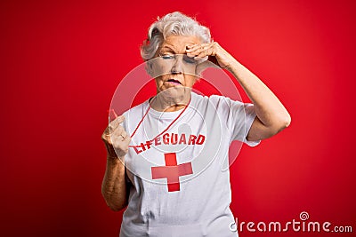 Senior beautiful grey-haired lifeguard woman wearing t-shirt with red cross using whistle worried and stressed about a problem Editorial Stock Photo