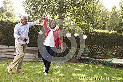 Senior black couple dance in their back garden, full length Stock Photo