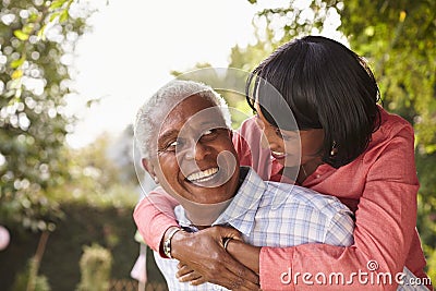 Senior black couple piggyback, looking at each other Stock Photo