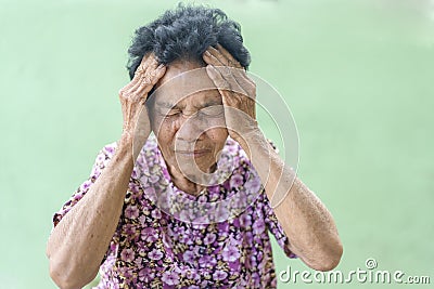 Senior black-haired woman touching head with hand with painful expression because of headache. Mature woman suffering from Stock Photo