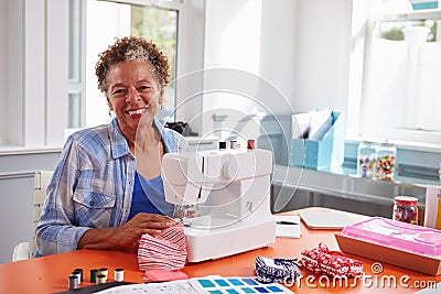 Senior black woman using a sewing machine looking to camera Stock Photo