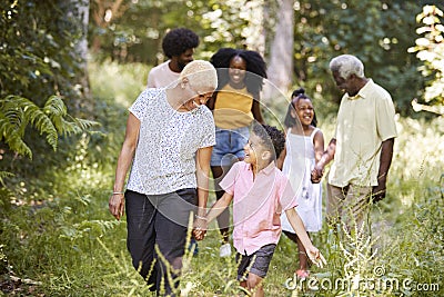 Senior black woman walking with grandson and family in woods Stock Photo