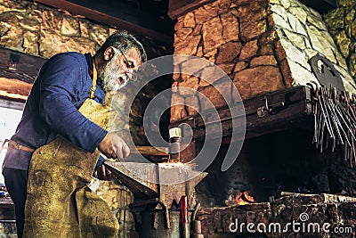 Senior blacksmith forge iron Stock Photo