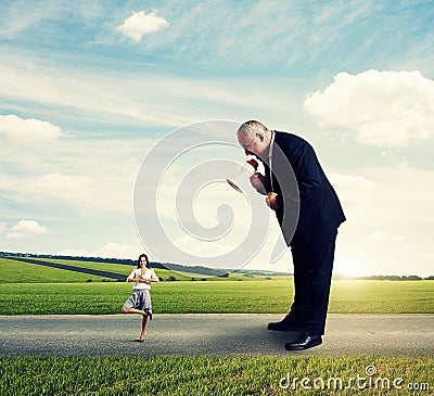 Senior boss screaming at calm smiley woman Stock Photo