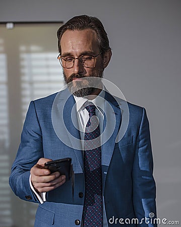 Senior business man receiving message on his cell phone Stock Photo