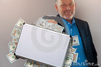 Senior businessman with briefcase full of dollars Stock Photo