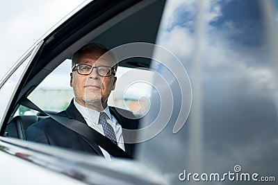 Senior businessman driving on car back seat Stock Photo
