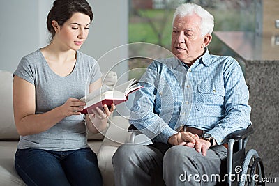 Senior care assistant reading book Stock Photo