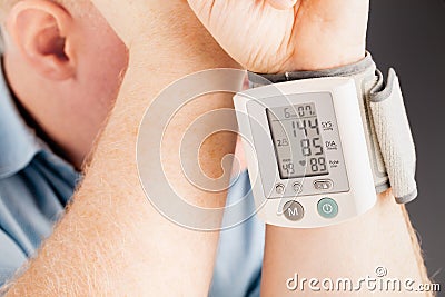 Senior caucasian retired male taking blood pressure at home Stock Photo