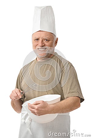 Senior chef whisking egg in kitchen Stock Photo