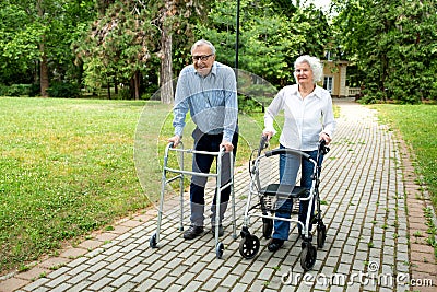 Senior citizens walking through the park with walking aid Stock Photo