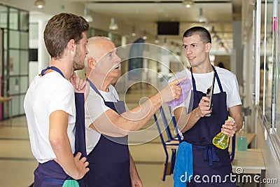 Senior cleaner explaining job to younger coleagues Stock Photo