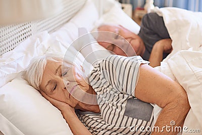 Senior couple asleep in their bed at home Stock Photo