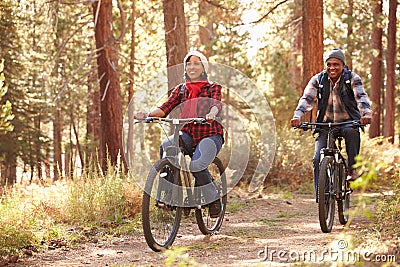 Senior Couple Cycling Through Fall Woodland Stock Photo