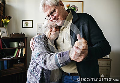 Senior couple dancing together at home Stock Photo