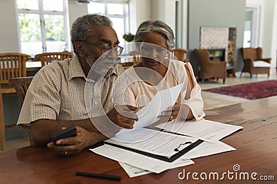 Senior couple discussing over invoices at home Stock Photo