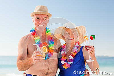 Senior couple drinking a cocktail on the beach Stock Photo