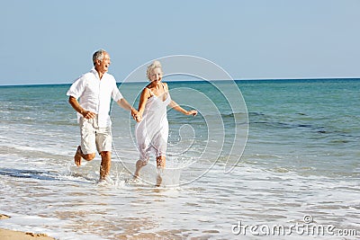 Senior Couple Enjoying Beach Holiday In The Sun Stock Photo