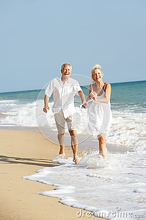 Senior Couple Enjoying Beach Holiday In The Sun Stock Photo