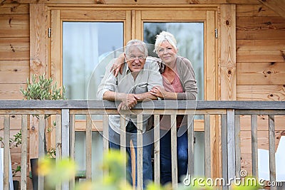 Senior couple enjoying peaceful holidays in wooden cabin Stock Photo