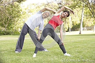 Senior Couple Exercising In Park Stock Photo