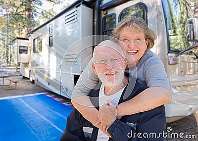 Senior Couple In Front of Their Beautiful RV At Campground. Stock Photo