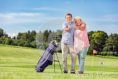 Senior couple giving thumbs up on a golf course. Stock Photo