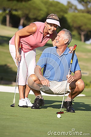 Senior Couple Golfing On Golf Course Stock Photo