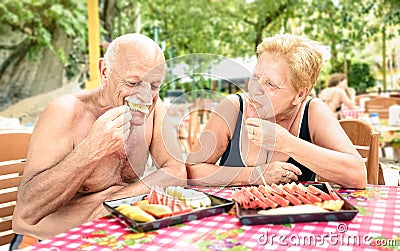 Senior couple having fun eating season fruit in thai restaurant Stock Photo