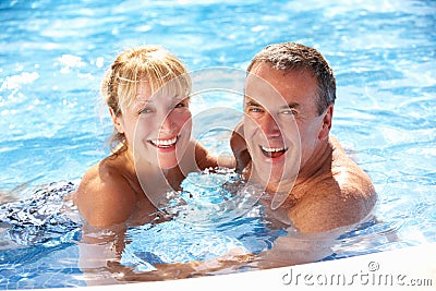 Senior Couple Having Fun In Swimming Pool Stock Photo