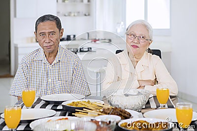 Senior couple having a meal at the dining table Stock Photo