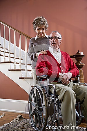 Senior couple at home, man in wheelchair Stock Photo