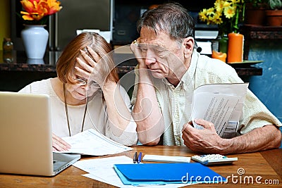 Senior couple at home with many bills Stock Photo