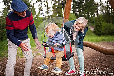 Senior couple with little boy at the playground. Stock Photo