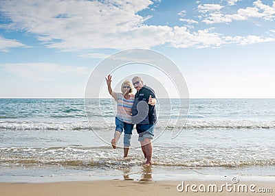 Senior couple in love walking on the beach having fun in a sunny day Stock Photo